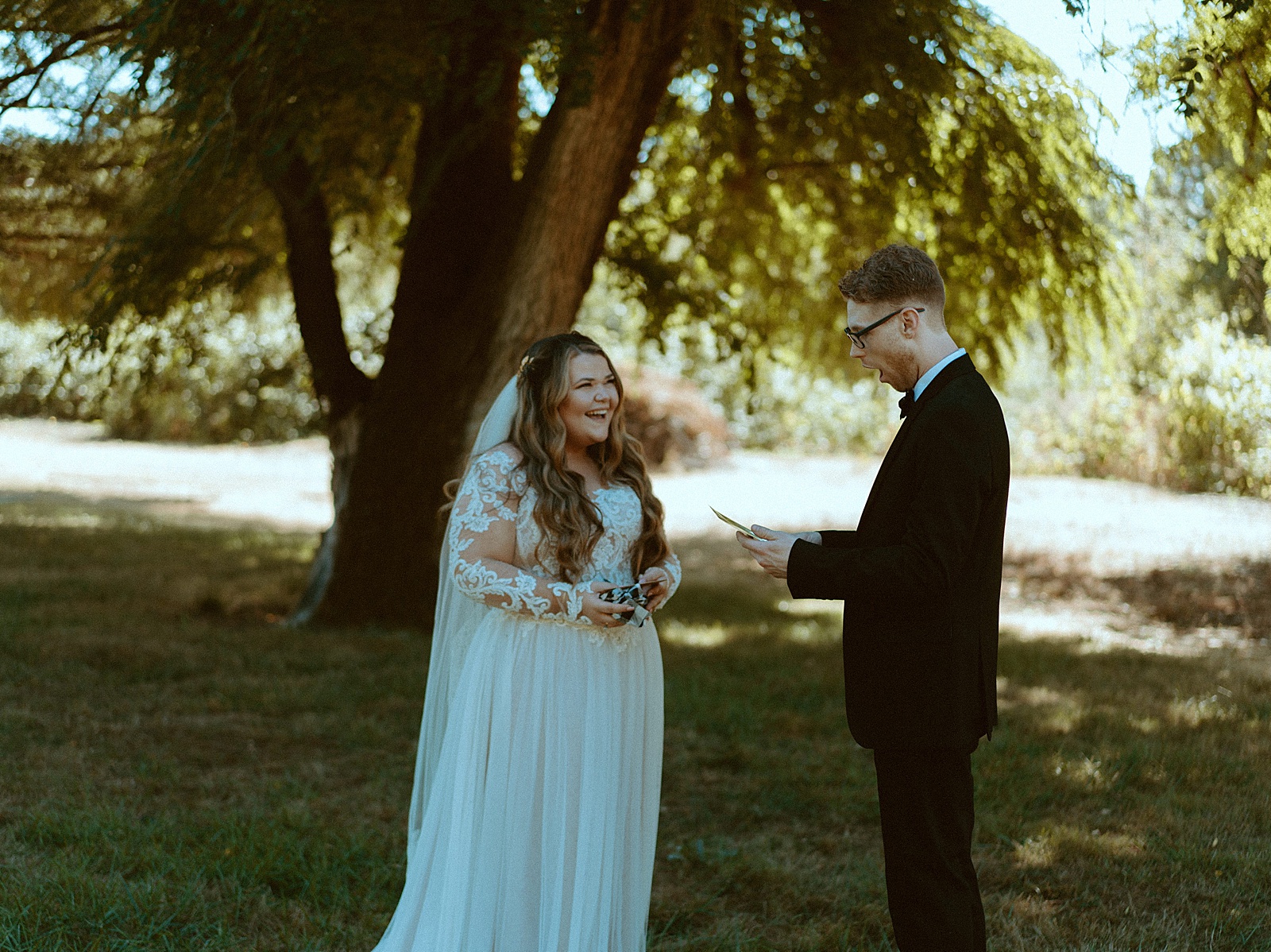 Bride and groom first look under trees exchanging gifts by Danielle Johnson Photography