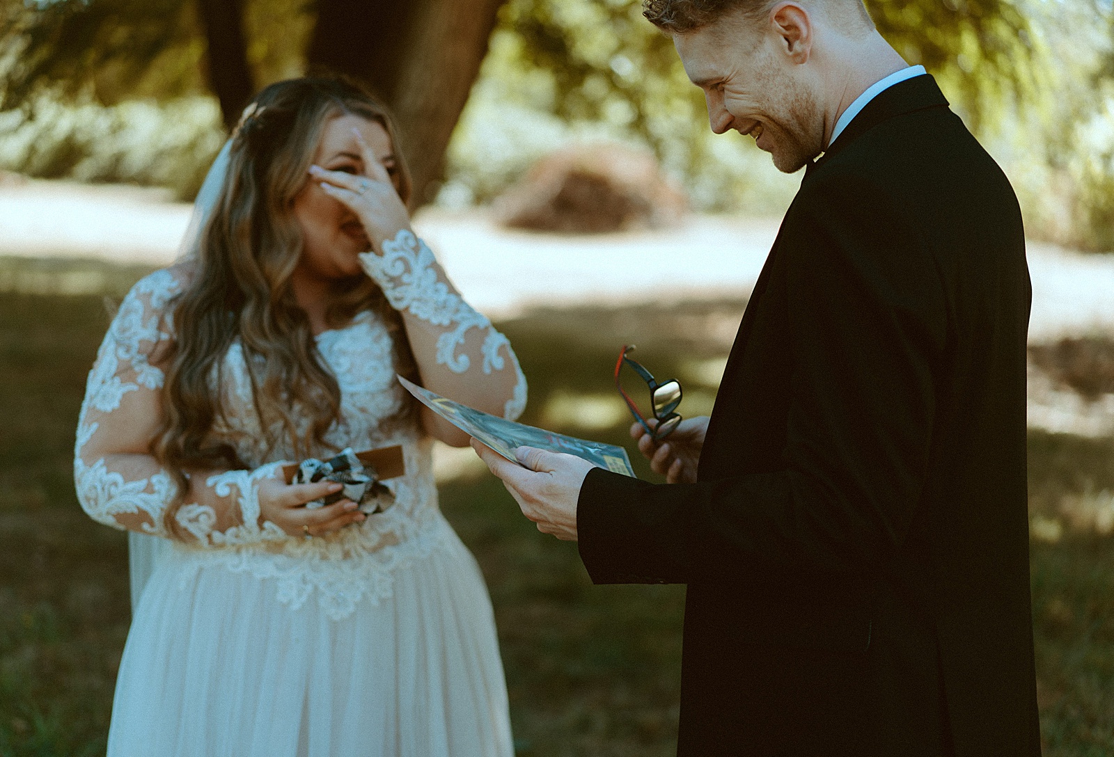 Bride and groom first look under trees exchanging gifts by Danielle Johnson Photography